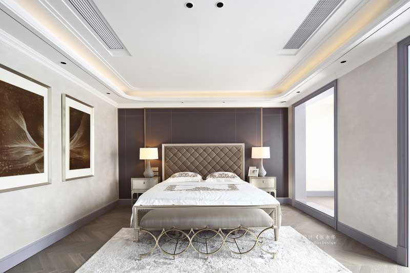 三樓是整個主臥空間，擁有內門廳、主臥室、衣帽間、衛生間等。主臥背景選用深灰色的硬包裝飾，加上金屬線條的點綴，讓整個背景不顯呆板。主臥陽臺同樣打通與臥室形成一體，局部空間做了地臺，讓整個空間既寬敞又有層次。