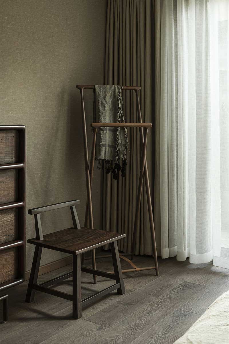 精美的木質斗柜與座椅、掛衣架，柔雅與硬朗并存，簡樸內斂，閃著溫潤的色澤，將空間的“木語”敘說到極致。