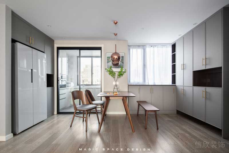 因?yàn)閺N房格局較小，所以體積龐大的雙開門冰箱被安置在外部的定制柜內(nèi)，平日里在客廳休息時(shí)取用放置也很方便。