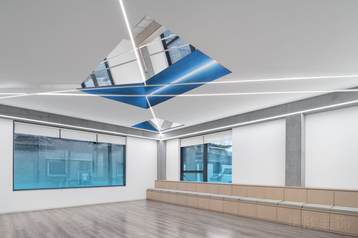 原木風收納柜設計效果天花直線式燈飾設計漸變藍色玻璃隔斷多功能教室裝修休息區(qū)