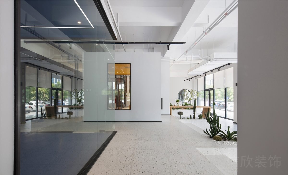 辦公室裝修設計現(xiàn)代工作室玻璃隔斷過道水磨石波點地板白色瓷磚過道